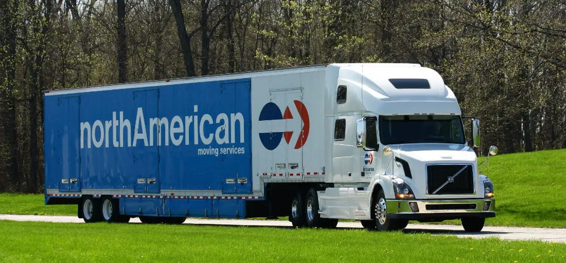 A large truck driving down the road in a field.